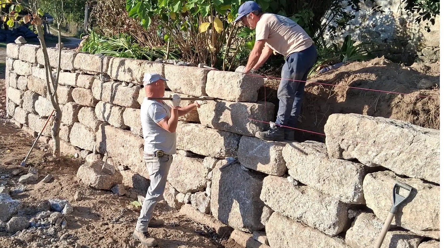 Pedreiro minhoto a trabalhar granito em Guimarães — tradição viva em cortes de água, soleiras e molduras