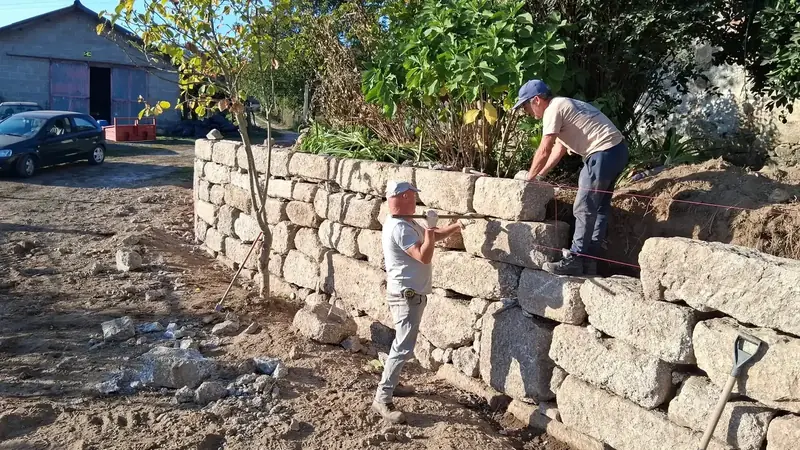 Equipa da Motivo Rústico a construir um muro em granito